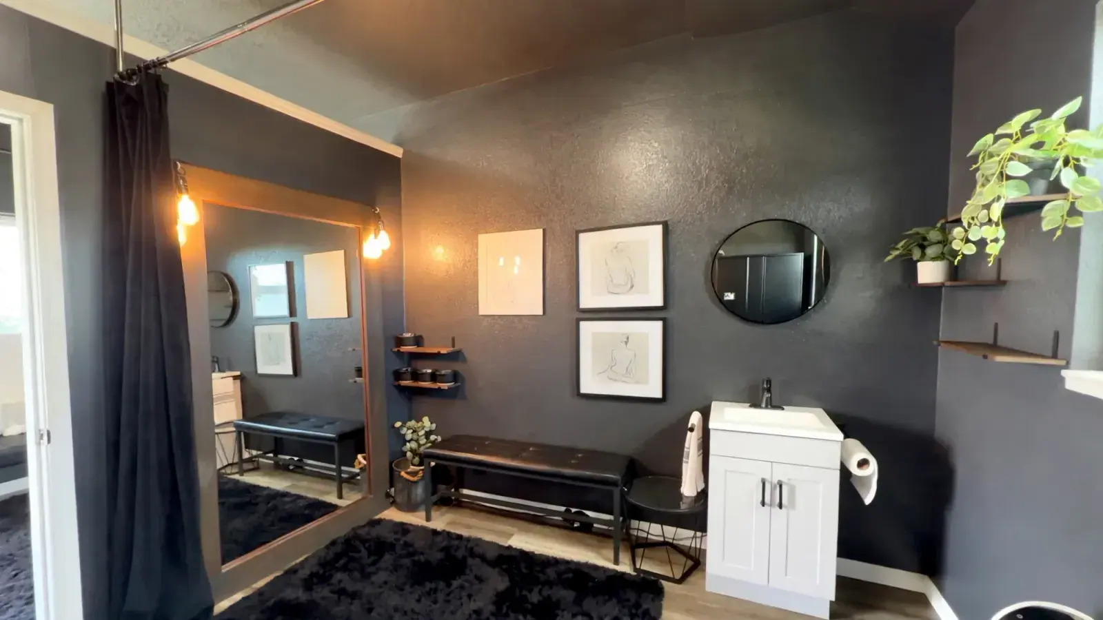 The private treatment room at deSoleil, with soft lamplight, a tufted bench and framed line drawings on charcoal walls
